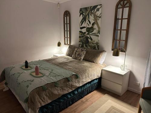 a bedroom with a bed with a green comforter at Cozy Inn in Perth