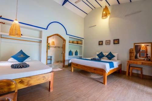 a bedroom with two beds and a mirror at Khu Nghỉ Dưỡng Green Bungalow Phu Quoc in Phu Quoc