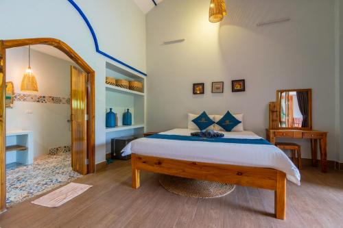 a bedroom with a large bed and a mirror at Khu Nghỉ Dưỡng Green Bungalow Phu Quoc in Phu Quoc