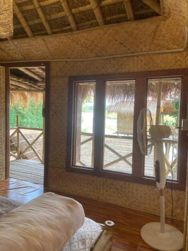 a view of a room with windows and a fan at Happy Lemon Tree lodge in Sauraha