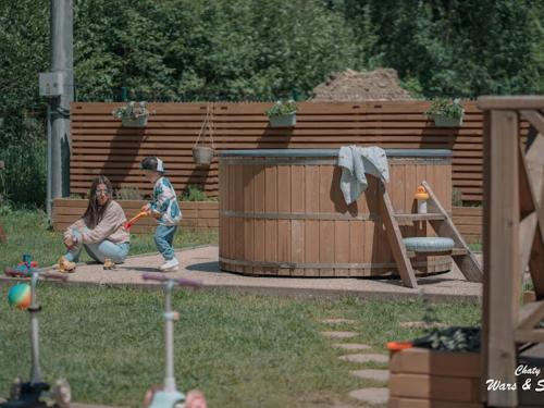 a woman and a child playing in a garden at Drevenice Wars & Sawa in Oščadnica