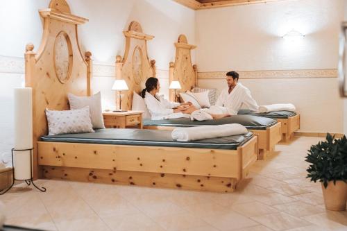 a group of three people sitting on beds in a room at Hotel Schneider Dependance in Obertauern
