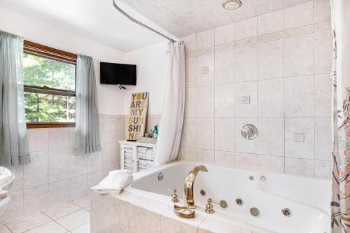ein Badezimmer mit einer Badewanne und einem Waschbecken in der Unterkunft Lakeview Lookout in Wisconsin Dells