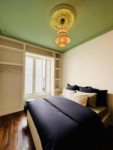 une chambre avec un lit bleu et un plafond vert dans l'établissement 2 pièces à Bastille, à Paris