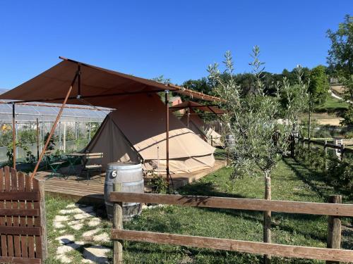 a tent in a field next to a fence at Terre del Piano-Bell Tent in Corinaldo