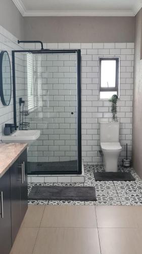 a bathroom with a shower with a toilet and a sink at One85 in Vinko in Pretoria