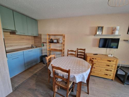 une cuisine avec une table et des chaises et une cuisine avec une télévision dans l'établissement Studio au pied des pistes avec balcon et parking - FR-1-516-58, à Les Deux Alpes