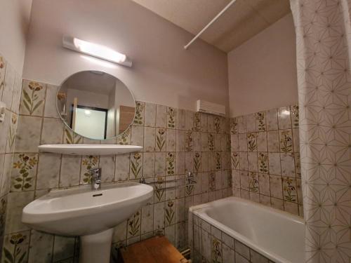 une salle de bain avec un lavabo, un miroir et une baignoire dans l'établissement Studio au pied des pistes avec balcon et parking - FR-1-516-58, à Les Deux Alpes