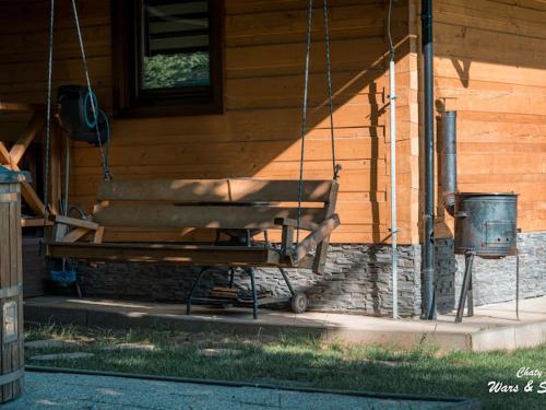 a bench hanging from a porch of a house at Drevenice Wars & Sawa in Oščadnica