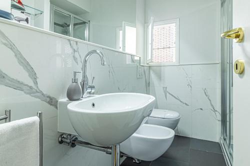 a white bathroom with a sink and a toilet at Casa Hygiea in Canton De' Fiori in Bologna