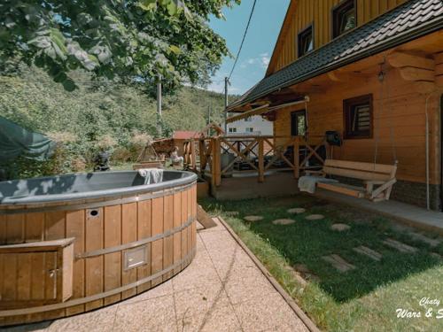 a hot tub in a yard next to a house at Drevenice Wars & Sawa in Oščadnica