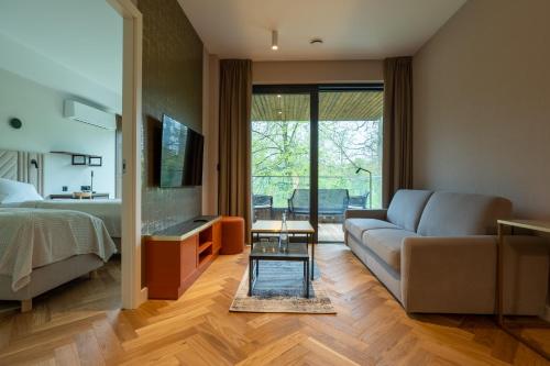 a living room with a couch and a bed at Enklawa Białowieska Forest & Spa in Hajnówka