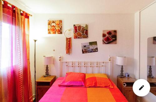 a bedroom with a bed with a colorful blanket at 2 CHAMBRES B&B PRÈS DE L'AÉROPORT ET DU MEETT in Blagnac