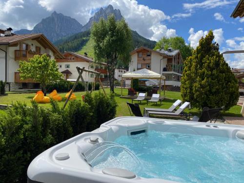 a hot tub in the yard of a house at Hotel Chalet Sas Morin in Pozza di Fassa