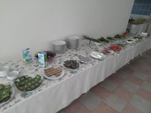 une longue table avec des assiettes de nourriture dans l'établissement Deniz Hotel, à Finike