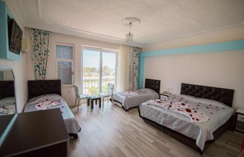a bedroom with two beds and a table in it at Deniz Hotel in Finike