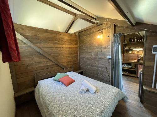 1 dormitorio con 1 cama en una habitación con paredes de madera en Terre del Piano, en Corinaldo