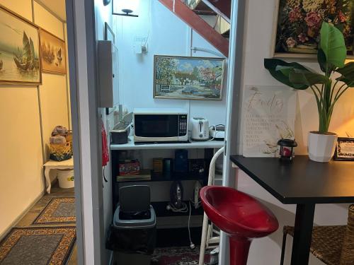 a small room with a table and a desk with a microwave at XYL Holiday Inn in Caloundra