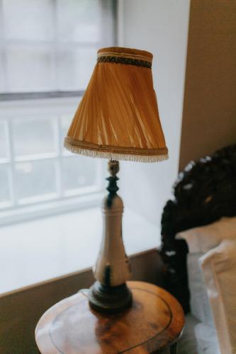 a table with a lamp on top of a table at Newton Hall in Chathill