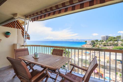 una mesa y sillas en un balcón con vistas al océano en UHC Sorolla Apartments en Salou