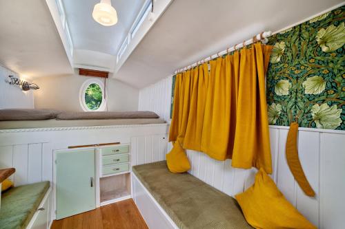 een kleine kamer met gele gordijnen en een raam bij Camping Passeier Glamping Tilia in Saltusio