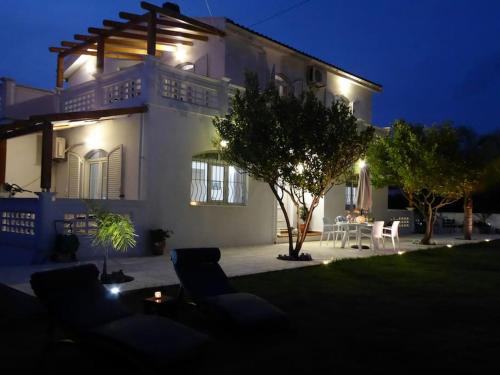 a large white house with a patio at night at Villa Alexia in Souda