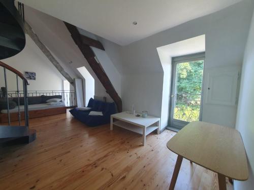 een grote woonkamer met een bed en een tafel bij Maison en pierre dans son nid de verdure in Roz-Landrieux