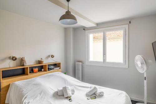 une chambre blanche avec un lit et une fenêtre dans l'établissement Appartement Daillon - Welkeys, à Toulon