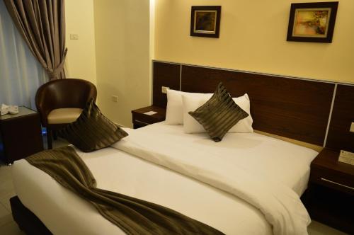 a hotel room with a bed and a chair at Ream Hotel Amman in Amman