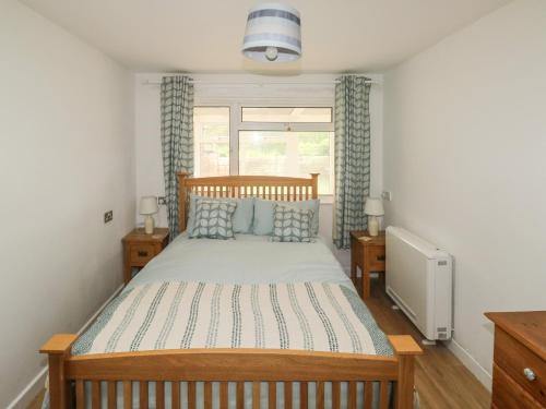 a bedroom with a large wooden bed with blue pillows at Sunny Breeze in Kingsbridge