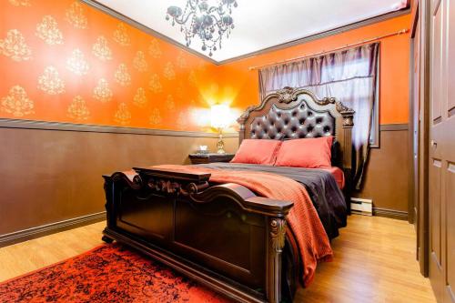 1 dormitorio con 1 cama con pared de color naranja en Private bedrooms+free parking en Lower Sackville