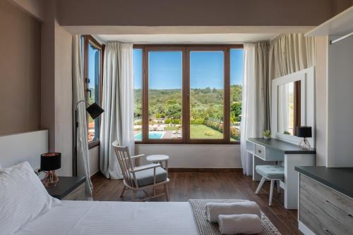 Schlafzimmer mit einem Bett, einem Schreibtisch und einem großen Fenster in der Unterkunft Arteon Villas in Agios Nikolaos
