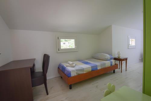 een kleine slaapkamer met een bed en een bureau bij Brseč Villa AnDa s apartmanima i bazenom in Brseč