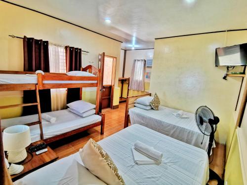 a room with two bunk beds in a room at Besaga Beachfront B&B - Port Barton in San Vicente