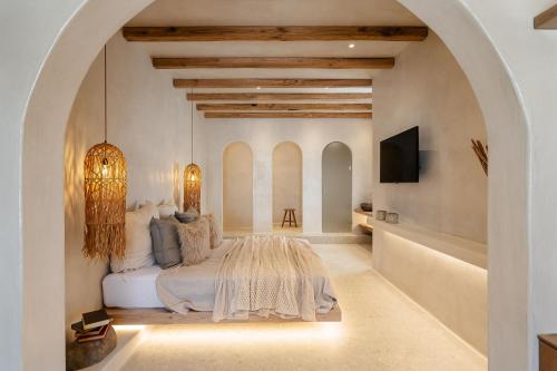 a bedroom with a bed and a tv in a room at Stoa Suites in Naxos Chora
