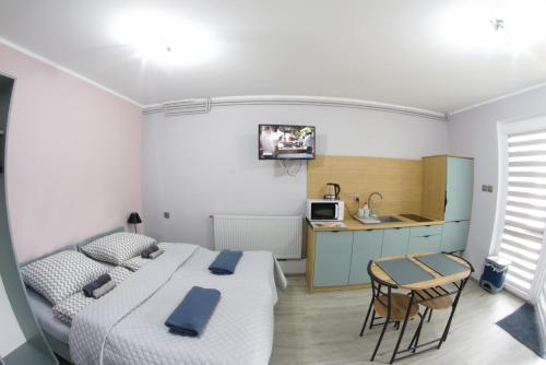a bedroom with a bed and a small kitchen at Dla Dwojga in Solina
