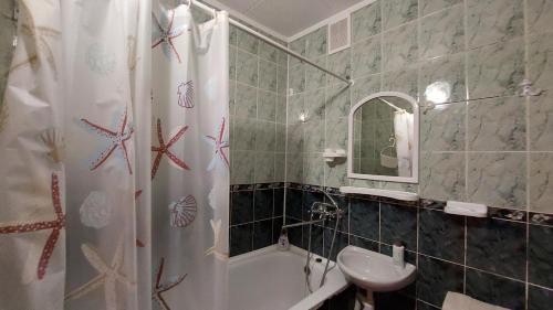 a bathroom with a shower curtain and a sink at Економ у центрі 3 кімнати in Luts'k