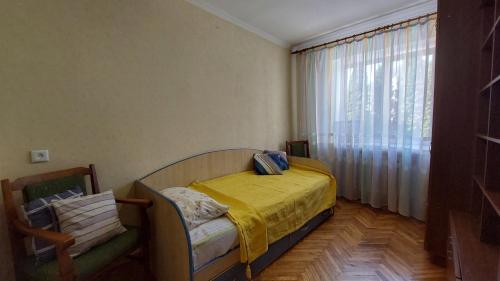 um pequeno quarto com uma cama e uma janela em Економ у центрі 3 кімнати em Lutsʼk
