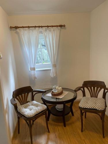 a dining room with a table and chairs and a window at Pension Soutěsky in Hřensko