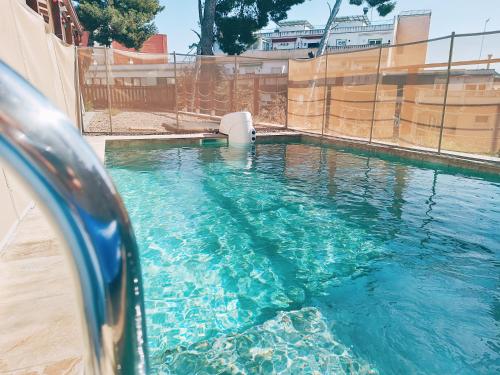 a swimming pool with blue water in front of a fence at House with pool near Park Guell in Barcelona