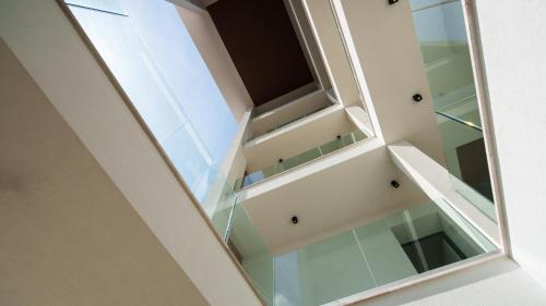 Una escalera de cristal en una casa con ventana en Welcomely - Affittacamere Seamphony Rooms, en Olbia