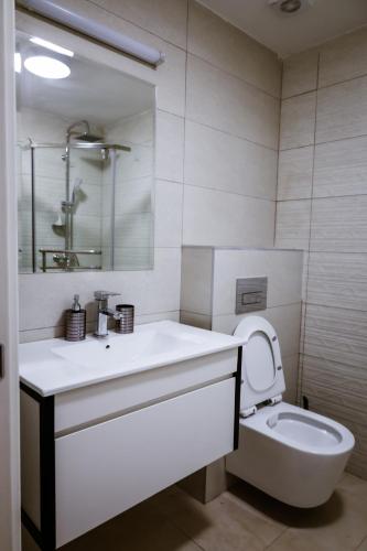 a white bathroom with a sink and a toilet at Apartment Neiv in Tivat