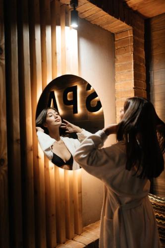 a woman getting her hair done in front of a mirror at Karpaty Migovo in Migovo