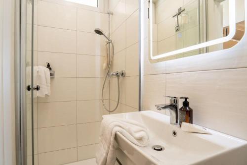 a white bathroom with a sink and a shower at Bellevue-Haus-B-Wohnung-13 in Großenbrode