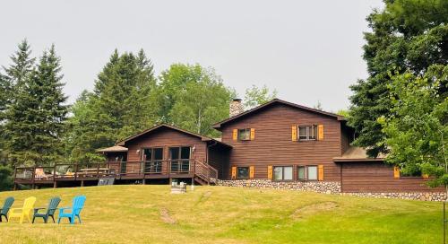 a house on a hill with chairs in front of it at Peace Of Mind On Namakagon Condo in Namekagon