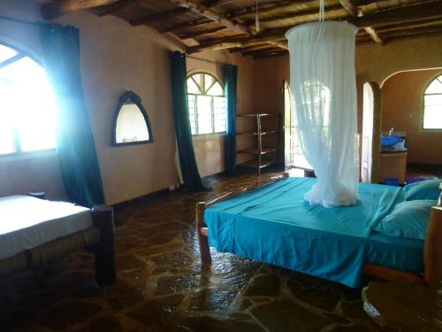 1 dormitorio con 1 cama azul con dosel en Room in Villa - A 37m2 suite in a 560 m2 Villa, Indian Ocean View, en Shimoni