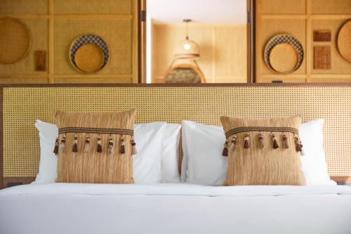 a bedroom with a bed with white pillows at LA COCOTTE VILLA & FARM KHAO YAI in Nong Sarai