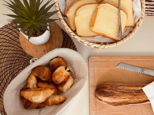 stół z chlebem i kosz chleba w obiekcie Hôtel le Nid w Argelès-sur-Mer