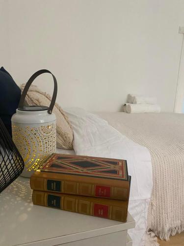 a stack of books sitting next to a bed at Studio agréable proche Tour Eiffel in Paris