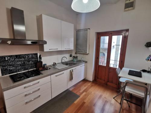 a kitchen with white cabinets and a stove top oven at Corso Italia in San Giovanni Valdarno